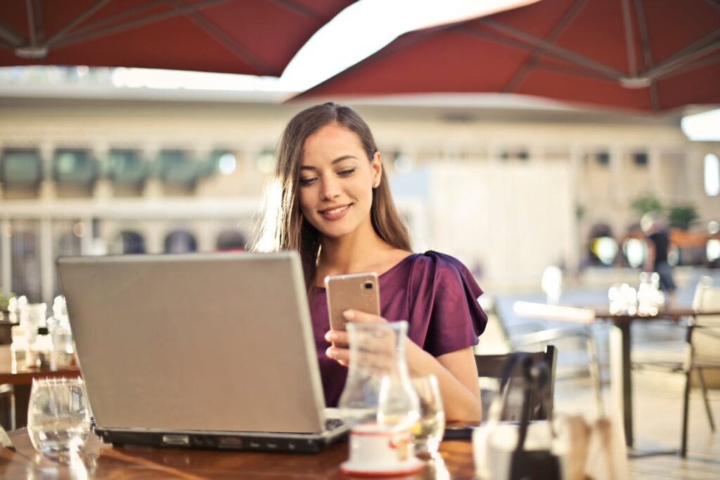 Frau im Café blickt auf ihr Smartphone Personalisierung von Smartphone-Zubehör Ein Blick auf Lifestyle und Nachhaltigkeit